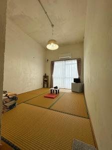 a room with a large yellow rug on the floor at Guesthouse Iyonchi in Zamami
