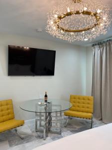 une salle à manger avec une table en verre et deux chaises jaunes dans l'établissement Retreat at Crystal Manatee, à Crystal River