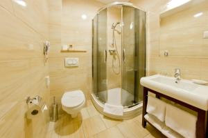 a bathroom with a shower and a toilet and a sink at Hotel Columbus in Krakow
