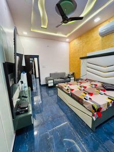 Ajmer villa -3 km from bus stand في أجمير: غرفة نوم بسرير وتلفزيون وأريكة