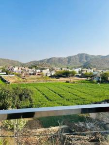 uitzicht op een groen veld met bergen op de achtergrond bij Ajmer villa -3 km from bus stand in Ajmer