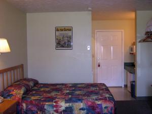 Murphy's Alaskan Inn في سيوارد: غرفة نوم بسرير وصورة على الحائط