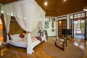 a bedroom with a bed with a canopy at Mandala Spa & Resort Villas in Boracay