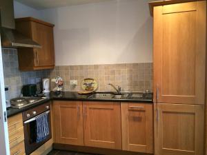 a kitchen with wooden cabinets and a sink at 39 Camden Wharf in Cork