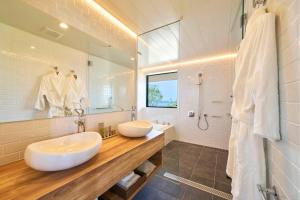 een badkamer met 2 wastafels en een douche bij 瀬戸内ゴルフリゾートヴィラ 