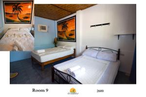 a room with two beds and a picture of palm trees at Ocean Mist Tourist Inn in San Vicente