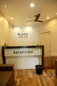 een lobby met een receptie en een bord met plaza 20 bar bij Plaza Tourist Home in Kannur