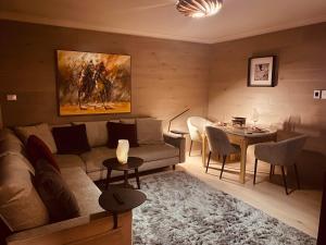 斯瑞德伯Chalet Charm E4 Mowamba的客厅里有一张沙发和一张桌子。