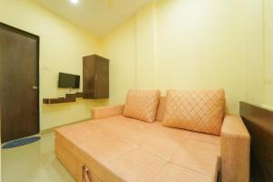 Habitación pequeña con sofá y TV. en Berry Fresh Stays Mahabaleshwar With Pool en Mahābaleshwar