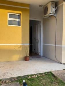 un bâtiment avec un mur jaune et une porte avec une fenêtre dans l'établissement Casa em Condomínio Fechado, à Pelotas