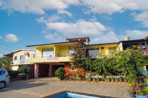 una casa gialla con una piscina di fronte di Berry Fresh Stays Mahabaleshwar With Pool a Mahabaleshwar