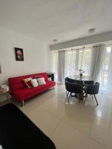 sala de estar con sofá rojo y mesa en Monoambiente Green Park- Solanas en Punta del Este