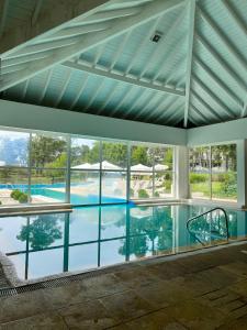 einem großen Pool mit Glasfenstern in einem Gebäude in der Unterkunft Solanas- Green Park - Punta del este in Punta del Este