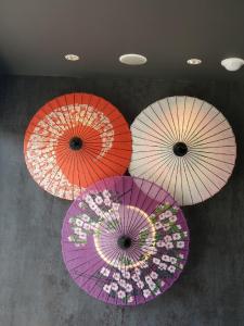 four different colored umbrellas hanging from a ceiling at Hotel IL Verde Kyoto in Kyoto
