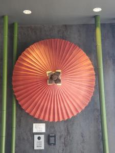 a large red paper umbrella hanging from a wall at Hotel IL Verde Kyoto in Kyoto +130 photos