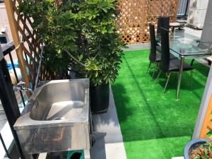 a balcony with a sink and a table and green grass at Hanmadang in Osaka