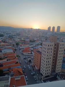 una vista de una ciudad con la puesta de sol en el fondo en Duplex dos Sonhos com Jacuzzi com cama King Size en Jundiaí