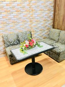 a coffee table with flowers on top of a couch at Hanmadang in Osaka