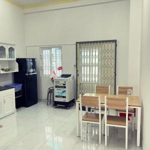 La cuisine est équipée d'une table, de chaises et d'un réfrigérateur. dans l'établissement Mai Anh Garden 2, à Soc Trang