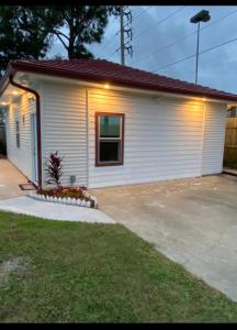 ein kleines weißes Haus mit einem Fenster in einer Einfahrt in der Unterkunft Southern’s Beauty 1 Very close to Airport in Kenner