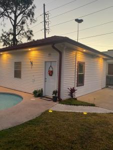 una pequeña casa blanca con una piscina frente a ella en Southern’s Beauty 1 Very close to Airport, en Kenner