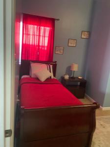 a bedroom with a red bed with a red window at Southern’s Beauty 1 Very close to Airport in Kenner