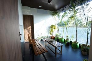 a room with a wooden bench and potted plants at DrizzleDrop Inn Chennai in Chennai