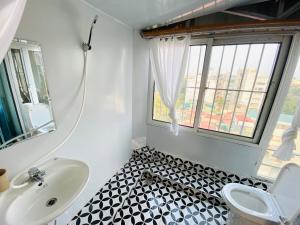 een badkamer met een wastafel, een toilet en een raam bij T - Apartment in Hanoi