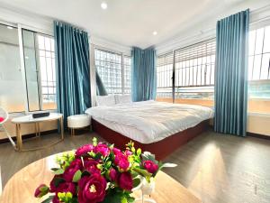 1 dormitorio con 1 cama y 1 mesa con flores en T - Apartment en Hanoi