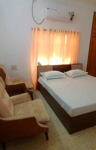 1 dormitorio con 2 camas, silla y ventana en Siddheshwara Home Stay, en Bangalore