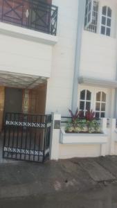 un edificio blanco con una puerta negra y plantas en Siddheshwara Home Stay, en Bangalore