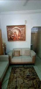 una sala de estar con sofá y una pintura en la pared en Siddheshwara Home Stay, en Bangalore