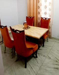 mesa de comedor con sillas y mesa de madera con tetera en Siddheshwara Home Stay, en Bangalore