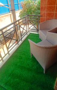 balcón con 2 sillas y césped verde en Siddheshwara Home Stay, en Bangalore