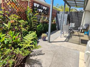a patio with plants and a table and chairs at Kerikeri Sunny Modern 2 Bedroom Apartment in Kerikeri
