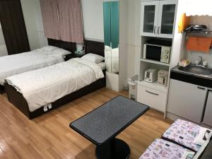 a small room with two beds and a kitchen at Hanmadang in Osaka