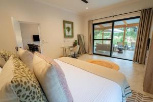 a bedroom with a bed and a view of a patio at Nomads Den Luxury Villa with Riverbed View in Hoedspruit