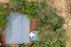 an overhead view of a house with a swimming pool and trees at Nomads Den Luxury Villa with Riverbed View in Hoedspruit
