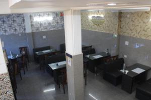a dining room with tables and chairs in a restaurant at SR Hotel & Restaurant 2.0 in Lohārakot