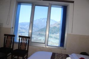 a bedroom with a large window with a view of mountains at SR Hotel & Restaurant 2.0 in Lohārakot