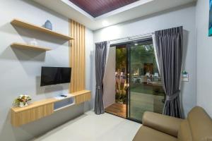 sala de estar con TV y sofá en Mook Anda Villa, en Ao Nang Beach
