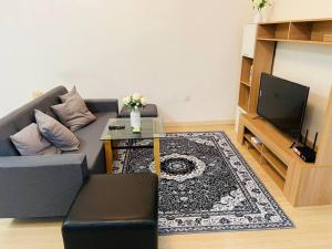 a living room with a couch and a tv at USJ One Residence Cozy Homestay Subang Jaya Sunway in Subang Jaya