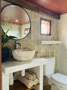 a bathroom with a large stone sink and a mirror at Santai House in Tetebatu