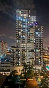 un palazzo alto con luci accese in una città di notte di USJ One Residence Cozy Homestay Subang Jaya Sunway USJ a Subang Jaya