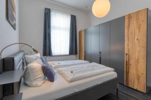 ein Bett in einem Schlafzimmer mit einem großen Fenster in der Unterkunft Buten un Binnen in Norderney