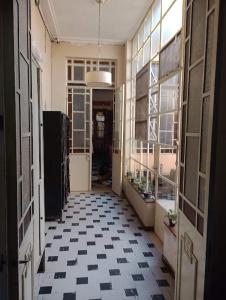 un pasillo vacío con suelo de baldosa blanco y negro en En La Plata Hostel El Pampa en La Plata