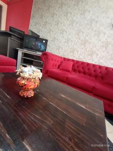 un sofá rojo en una sala de estar con mesa en En La Plata Hostel El Pampa en La Plata