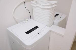 a white washing machine with a basket on top of it at 最大17名まで！羽田空港・東京駅の間にある平和島徒歩7分の貸切り一軒家 in Tokyo