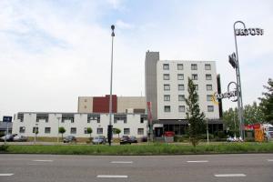 ein großes weißes Gebäude mit einer Straße davor in der Unterkunft Bastion Hotel Zaandam in Zaandam