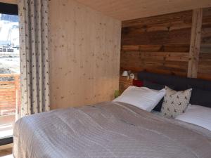 ザンクト・ローレンツェン・オプ・ムーラウにあるHoliday apartment Alpenblickの木製の壁のベッドルーム1室(ベッド1台付)